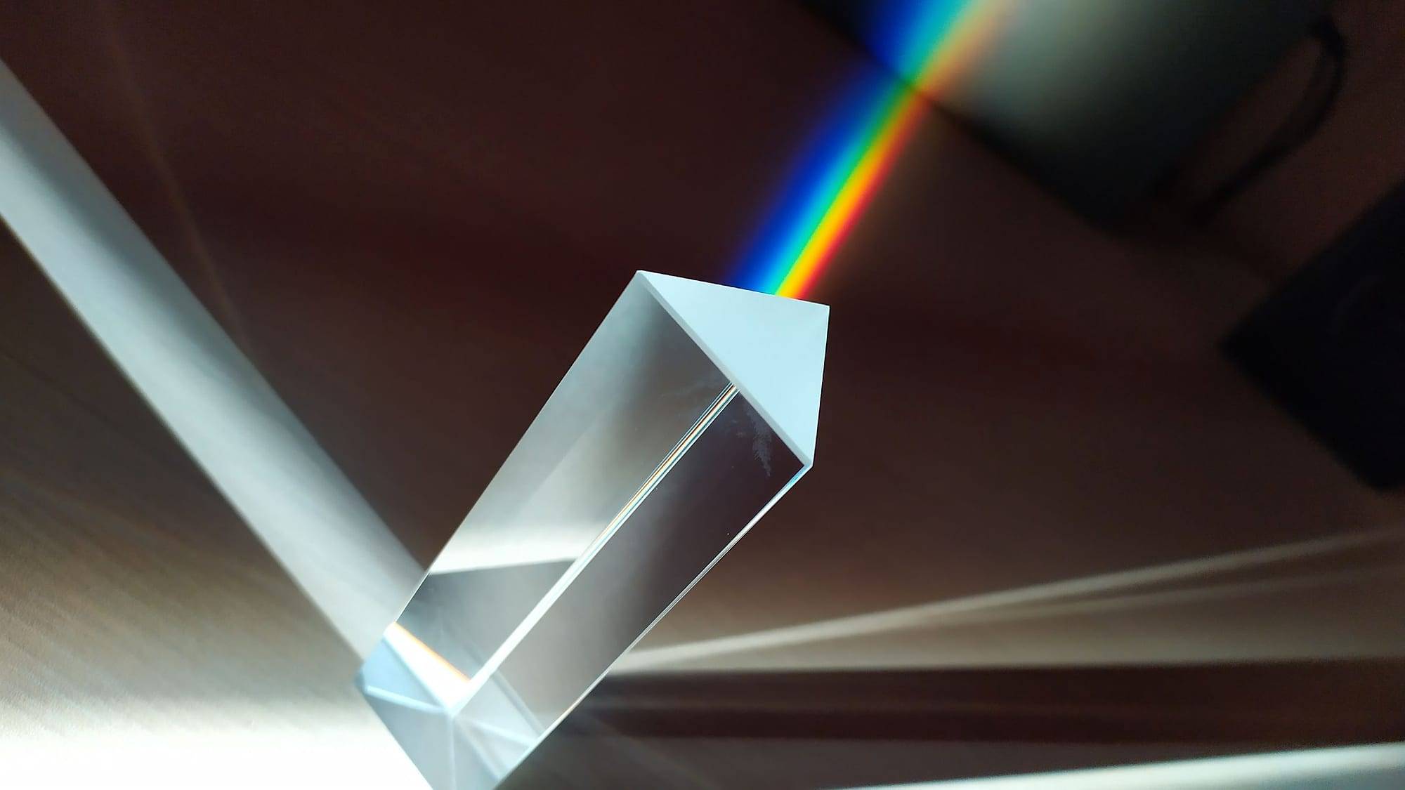Prisma de cristal descomponiendo un haz de luz en un arcoíris