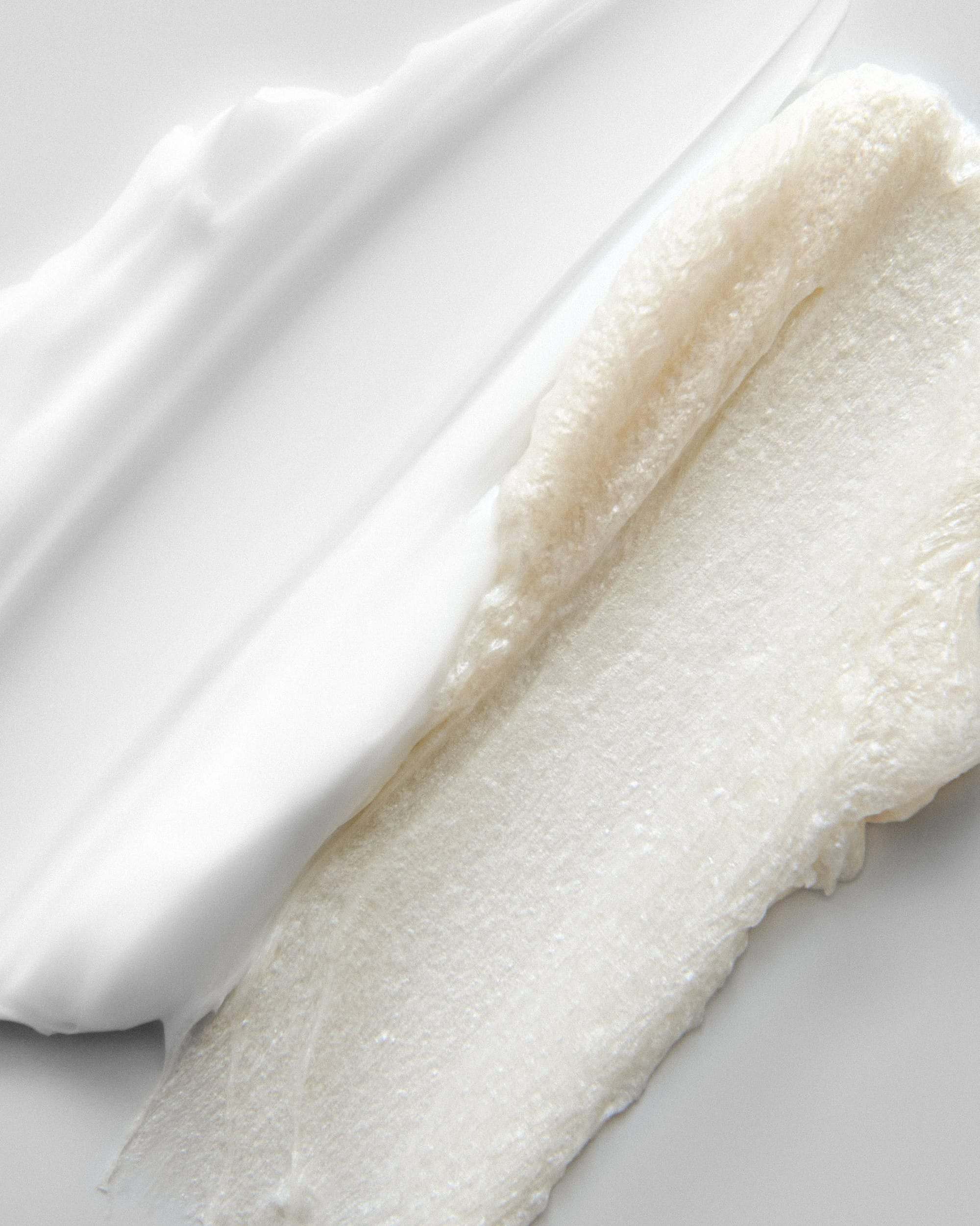 Texturas de crema y exfoliante blancas sobre fondo claro