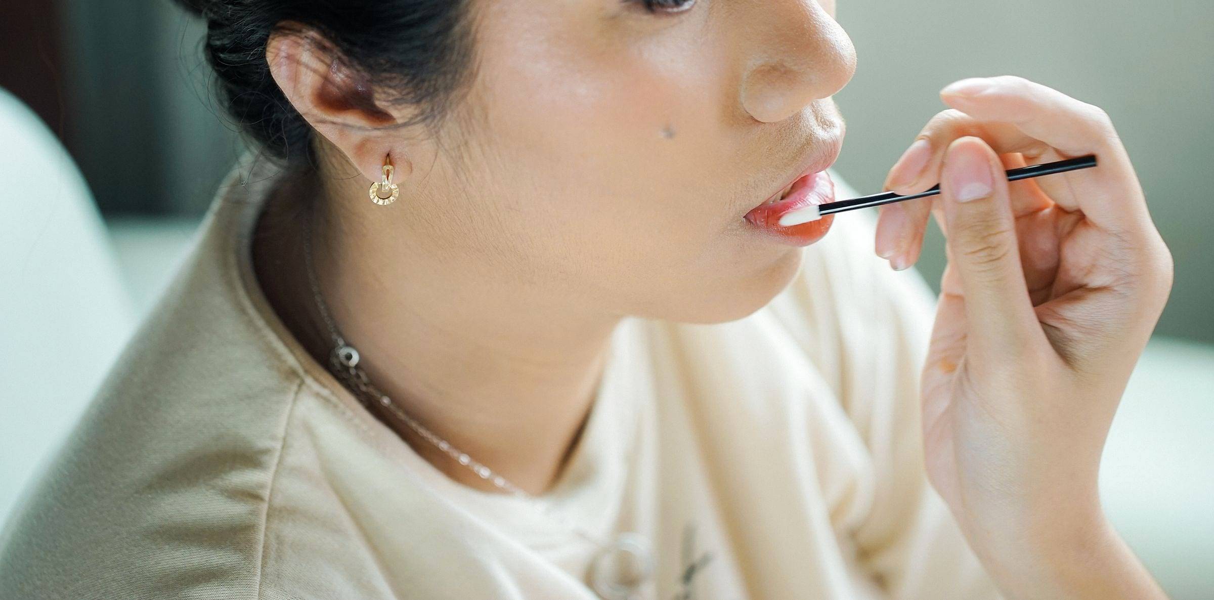Aplicación de tratamiento hidratante en los labios con pincel