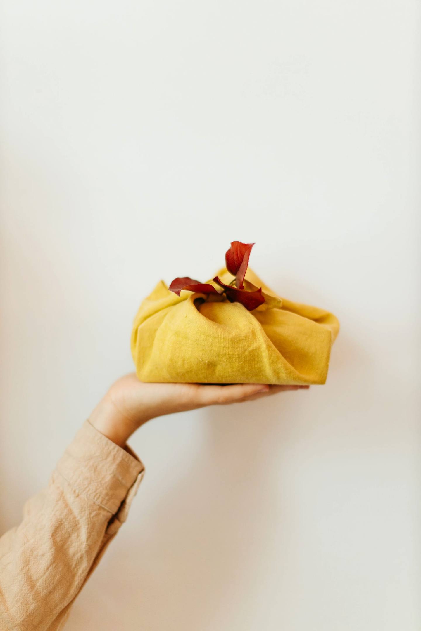 Regalo envuelto en tela al estilo furoshiki con una hoja roja