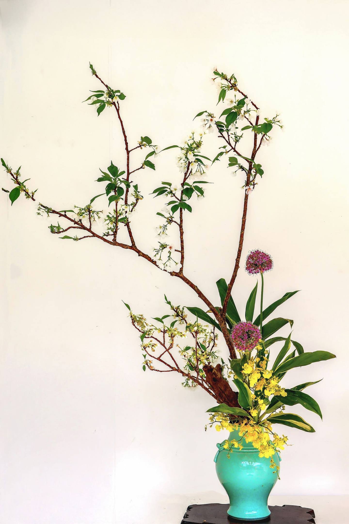 Arreglo de ikebana con ramas en flor sobre fondo claro