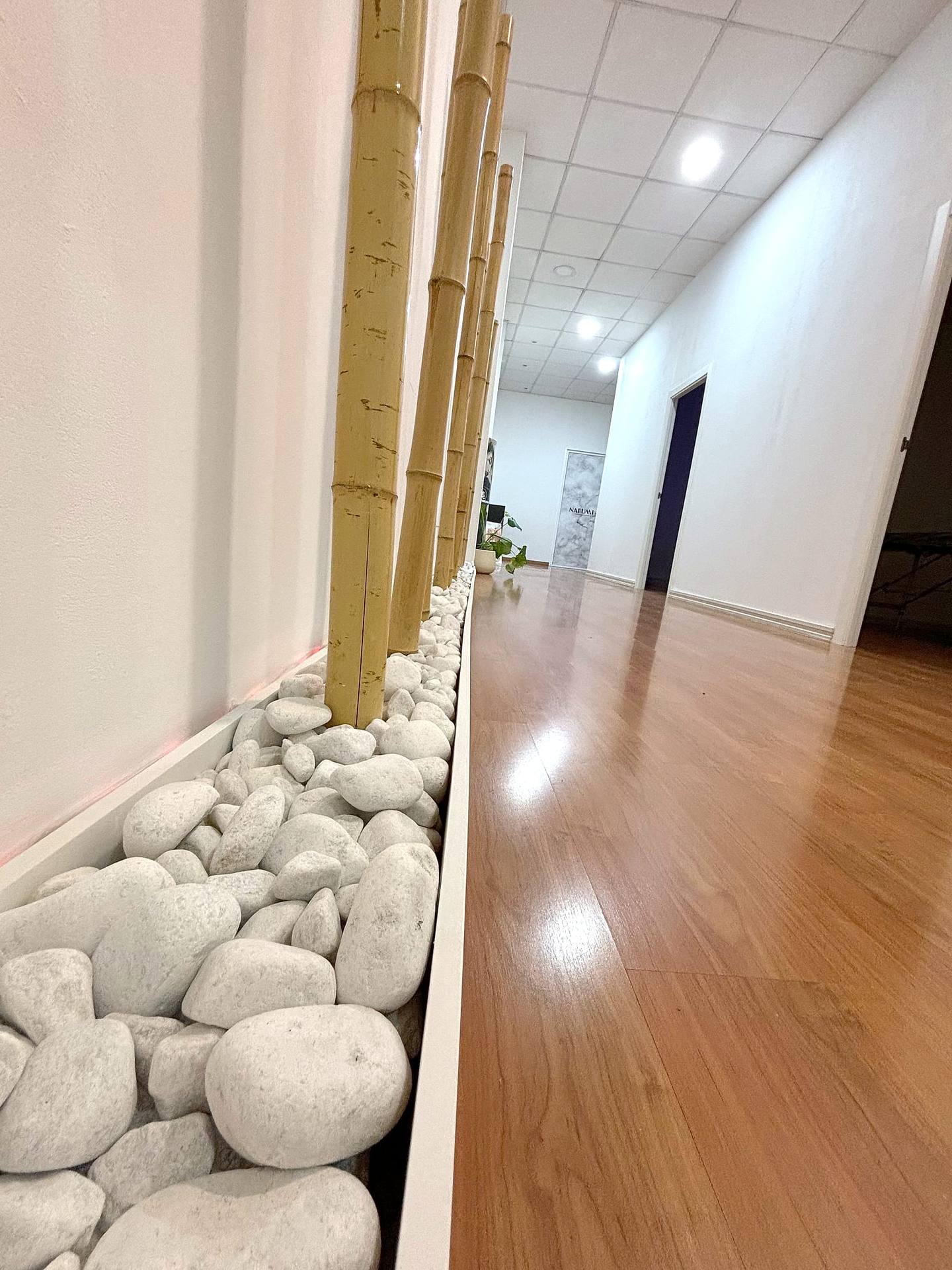 Pasillo del centro decorado con cañas de bambú y cantos rodados blancos